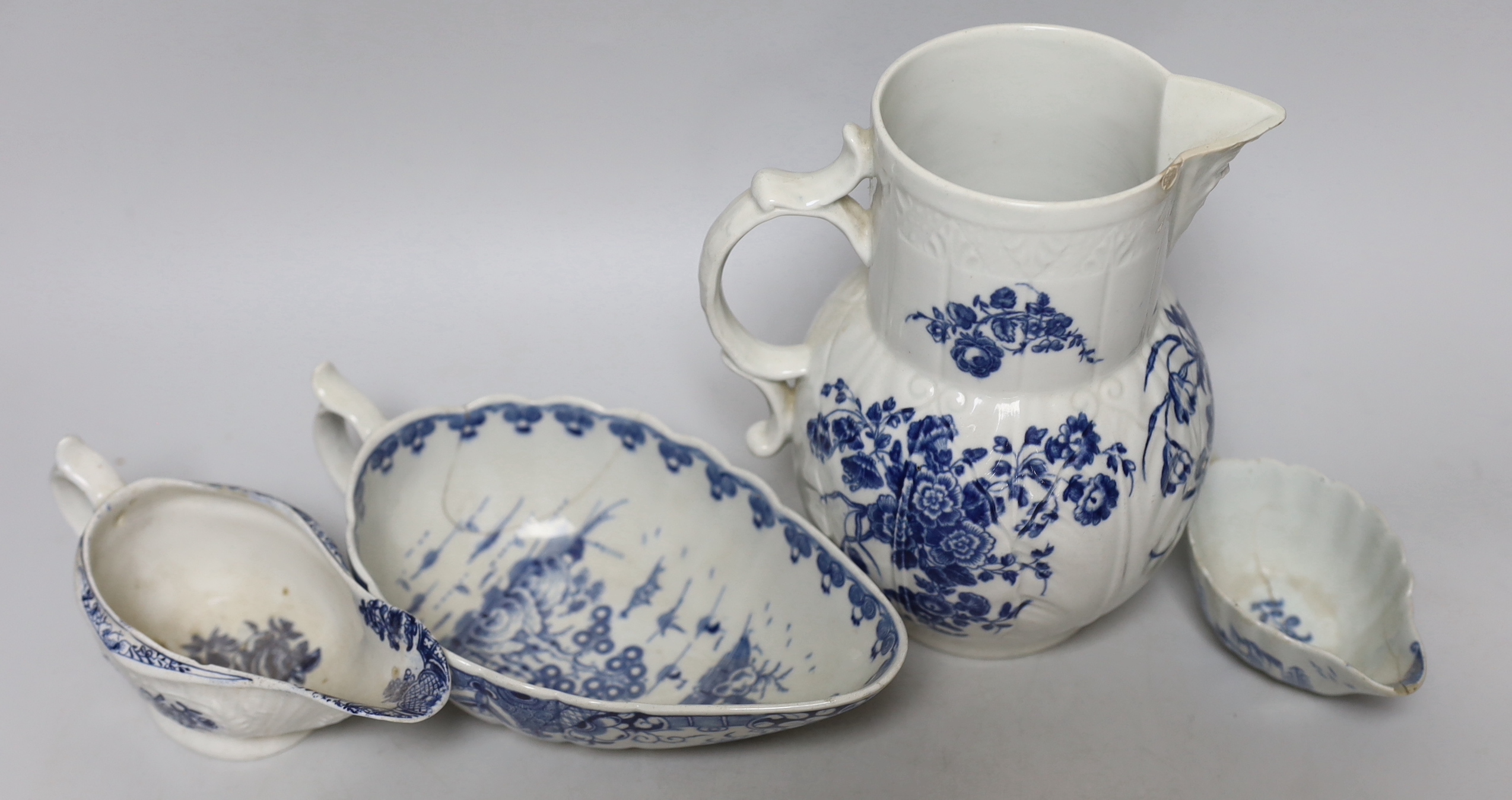 An 18th century Worcester blue and white cabbage-leaf mask jug, two similar sauceboats and an 18th century English blue and white sauceboat, a/f, tallest 19cm high